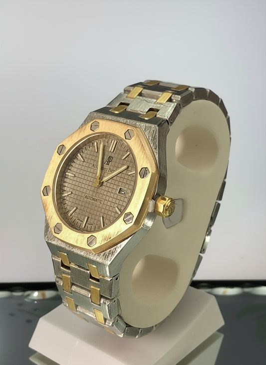 Two-tone watch with gold and silver band on a white background