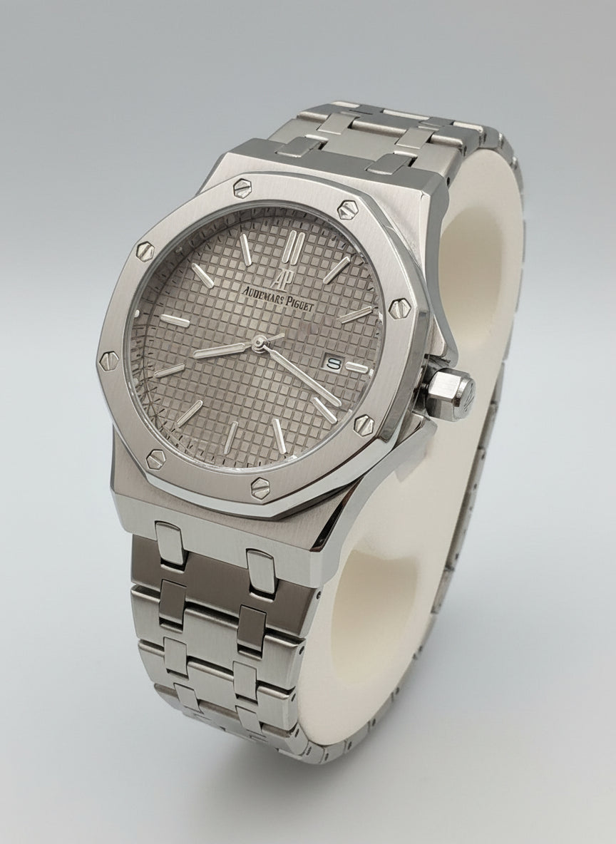 Silver watch with a textured face on a white stand against a blurred background