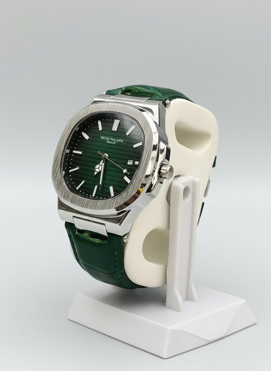 Green watch with a detailed face on a white stand against a green leafy background