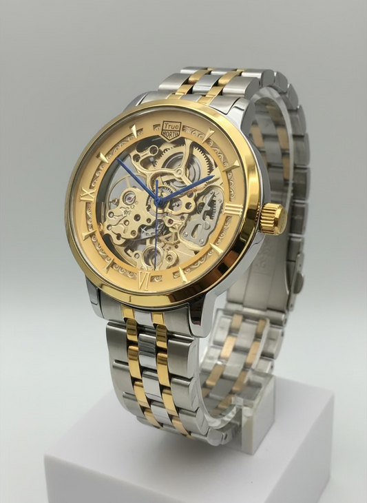 Gold and silver watch on a stand with a blurred background